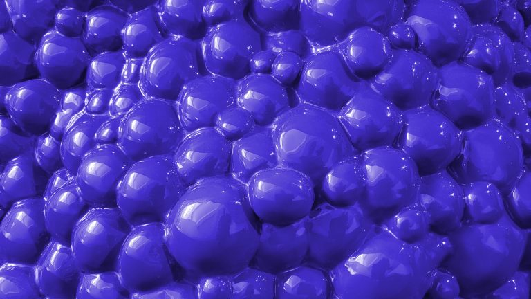 Close-up macro shot of transparent soap bubbles forming a complex, interconnected pattern with a bluish tint.