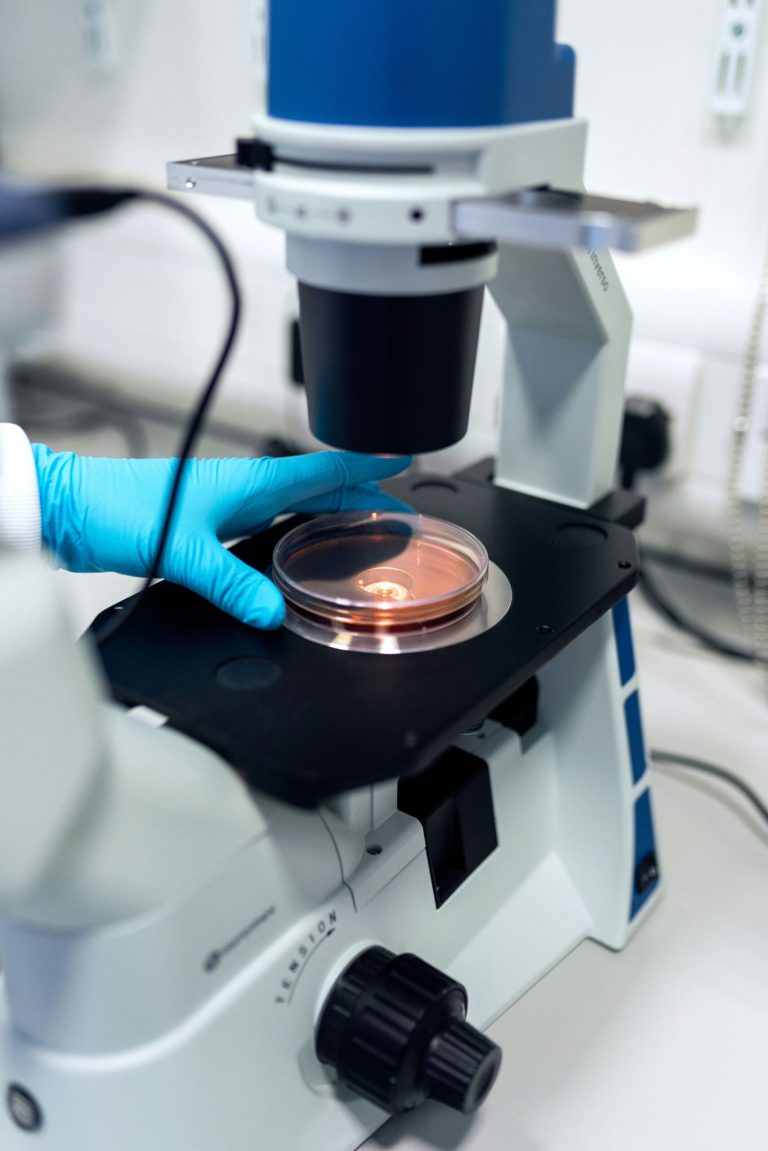 A magnifying glass placed over a newspaper page, enlarging a section of printed text under focused light, symbolizing close examination or scrutiny.